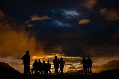 People marvelling at Montafon mountains with dramatic cloudy sky at sunset, Tschagguns, Rätikon,