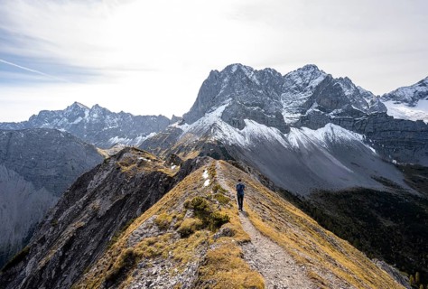 Mountaineer on a hiking trail on the ridge of Hahnkampl, mountain panorama with rocky steep peaks,