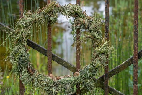 Decorative wreath, door wreath made of grass, hay tied to an iron gate, North Rhine-Westphalia,