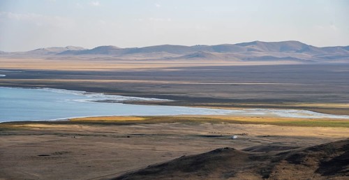 Mountain landscape with Lake Song Kul, view of yurts and horses on the lakeshore, Naryn region,