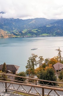 Tranquil landscape with lake, mountains and a boat in autumnal atmosphere, Lake Brienz,
