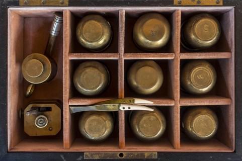 19th century cupping therapy set showing nine brass cups in antique wooden case
