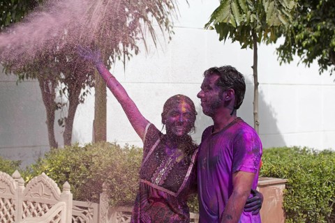 Young couple covered in colourful dye celebrating the Holi festival, Festival of Colours in