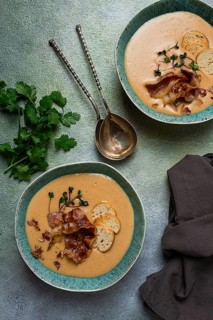 Pumpkin cream soup, curry, fried bacon, bruschetta chips, micro-greens, top view, no people