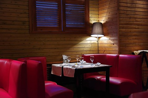 A cozy corner in a cafe, a table with a floor lamp in the twilight
