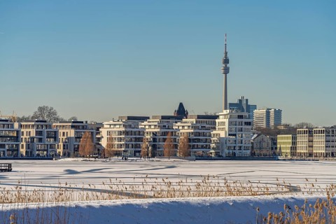 View of the snow-covered and frozen Phoenix Lake and the Florian television tower in Dortmund,