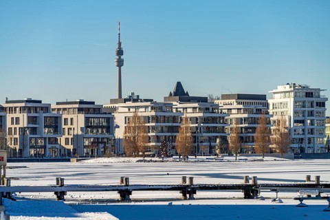 View of the snow-covered and frozen Phoenix Lake and the Florian television tower in Dortmund,