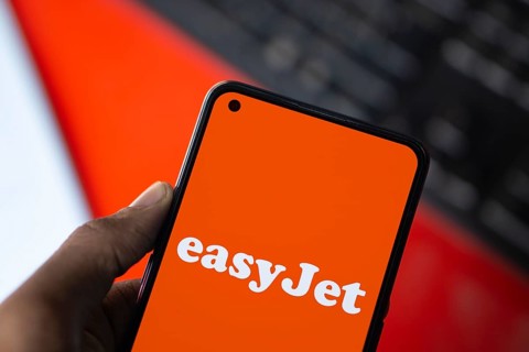 EasyJet logo is displayed on smartphone. EasyJet plc is a British multinational low cost airline