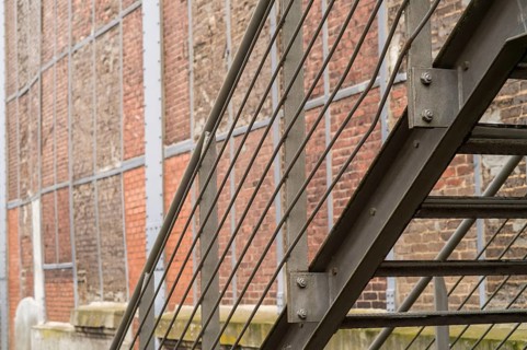 Close up of metal fire escape staircase on old brick wall building