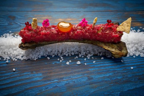 Steak tartar with egg yolk on half bone presentation modern cuisine