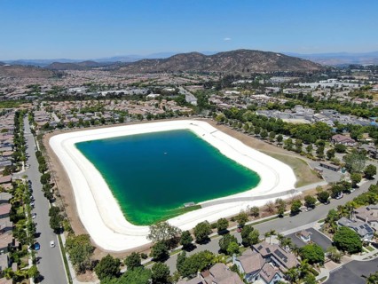 Aerial view of water recycling reservoir surrounded by suburban neighborhood in San Diego County,