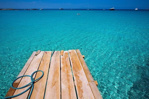Formentera Ses Illetes beach pier Illetas with Ibiza background at balearic islands