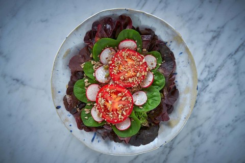 Tomato salad with seeds radish spinach and lettuces healthy food