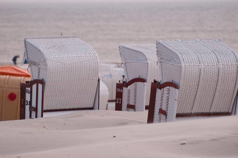 Empty beach chairs stand in a row overlooking the calm sea, Borkum, North Sea, GERMANY