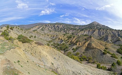 Clay ravines at the foot of the mountains. On the slopes of ravines one can see the structure of