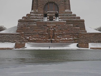 Lonely hiker at the wintry Völkerschlachtdenkmal. Leipzig, Saxony, Germany, Europe