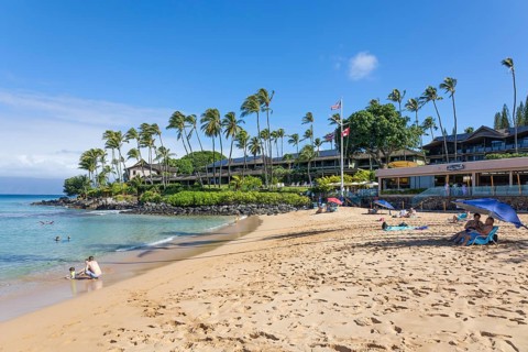 Tourist enjoying tropical beach with white sand and crystal clear water in Maui, Hawaii, USA,