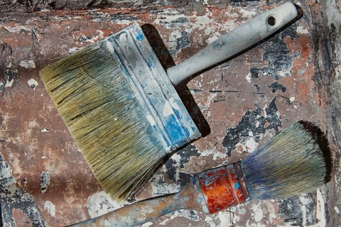 Paint brushes used on grunge bucket in improvement background