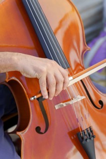 Close-up of unrecognizable man's hands playing the cello