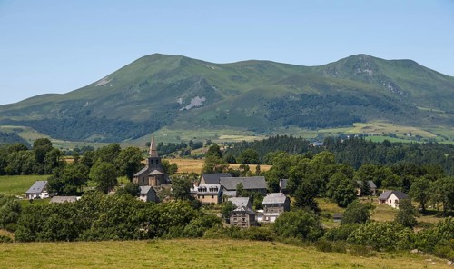 Scenic view of Saint Victor la Riviere village in Auvergne with Mont Dore mountains in the