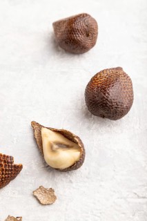 Salak or snake fruit on gray concrete background. Side view, close up. Tropical, healthy food,