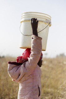 Girl carrying a heavy bucket of water on her head, Maraban Dare, 07/02/2024
