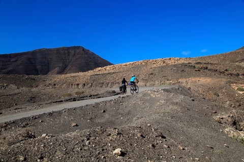 Cycling in barren landscape of Jandia peninsula Fuerteventura, Canary Islands, Spain, Europe