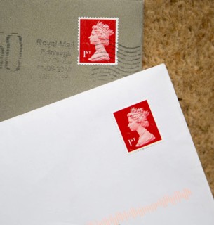 Looking down at letters in envelopes with red First class postage stamps, England, UK