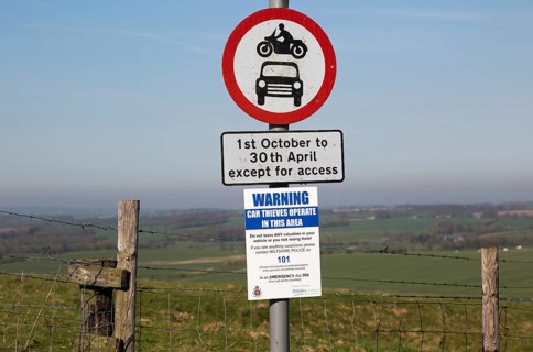 Road signs and car thieves warning sign, Ridgeway at Hackpen Hill, Wiltshire, England, UK