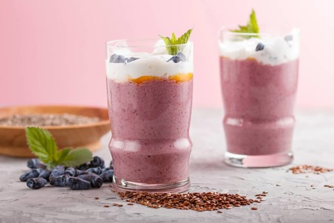 Smoothie with honeysuckle, linen and chia in a glass on gray concrete background. side view, close