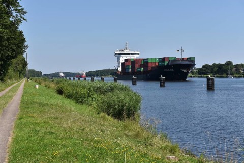 Container ship and cargo ships in a ship siding in the Kiel Canal, Kiel Canal, Schleswig-Holstein,