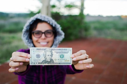 Happy Woman showing twenty dollar bill