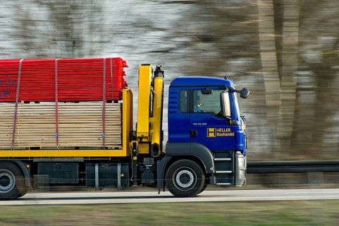 Truck, Truck MAN TGS 26.360 with building material driving fast on the motorway A92, motion blur,