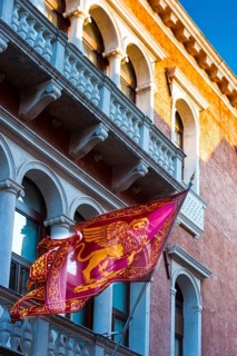 House facade and city flag with the lion of Venice, old building, city trip, holiday, travel,