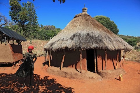 South Ethiopia, Benna people, house, hut, woman in front of her round hut in a Benna village,