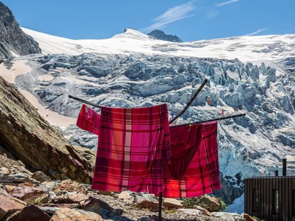 Colored bed linen dries in the sun, mountain hut Cabane de Moiry, located close to the retreating