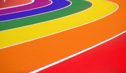 Symbolic image of queer in sport: Running track of an athletics facility in rainbow colours