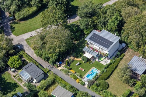 Aerial view of a modern house with garden, pool and solar panels on the roof, Vienna