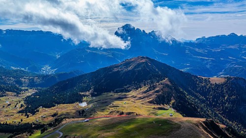 Summit of the Picberg, in the background the peaks of the Sassolungo group, shrouded in fog, drone