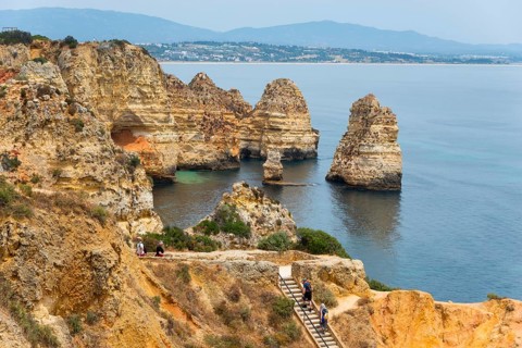 Visitors walk along a path on the cliffs that offers a breathtaking view of the sea and the rocks,