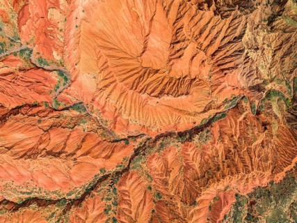 Eroded mountain landscape, top-down, canyon with red and orange rock formations, aerial view,