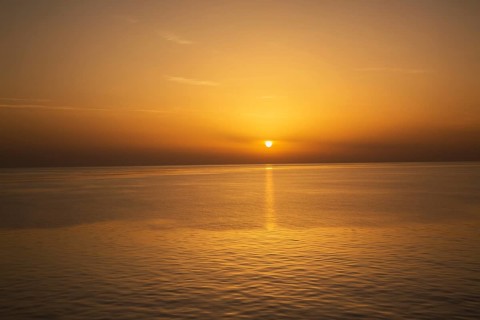 Setting golden sun over Adriatic sea taken from the top deck of a cruise ship in late summer, near