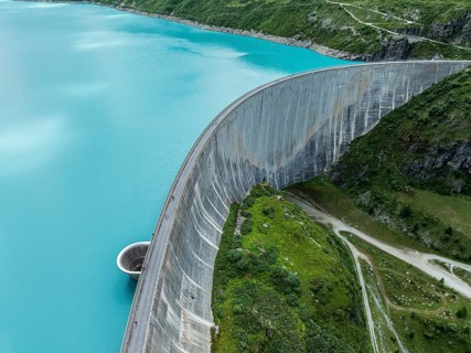 Dam of the Moiry lake, Lac de Moiry, turquoise glacial water, water overflow, tourists, aerial
