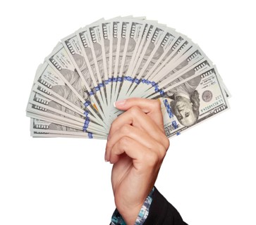 Female hand holding thousands of U.S. dollars in one hundred dollar bills isolated on white