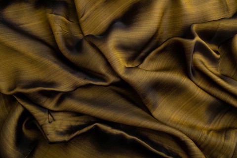 Fragment of yellow and green tissue. Side view, synthetic textile background and texture. wave