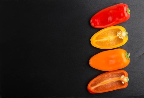 Yellow, red, orange sweet peppers on a black slate background. top view, copy space, flat lay,