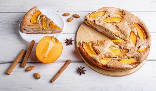 Sweet persimmon pie on white wooden background. close up