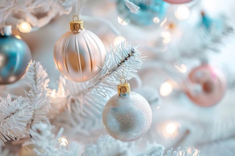 Close up of beautiful pastel colored bauble ornaments on branches of white christmas tree.