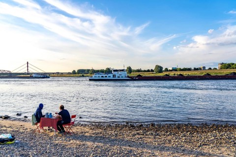 The Rhine at Duisburg-Baerl, man and woman having a picnic on the Rhine beach, at low tide, on the