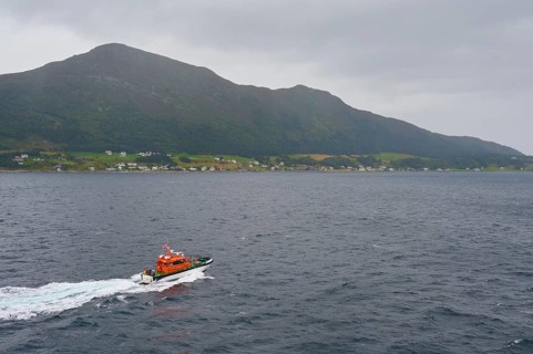 Pilot boat at sea, entrance to Alesund and island in the background, Alesund, Fylke, Norway, Europe